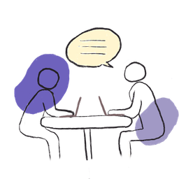 Two people talking across a table with laptops, representing one-to-one founder support